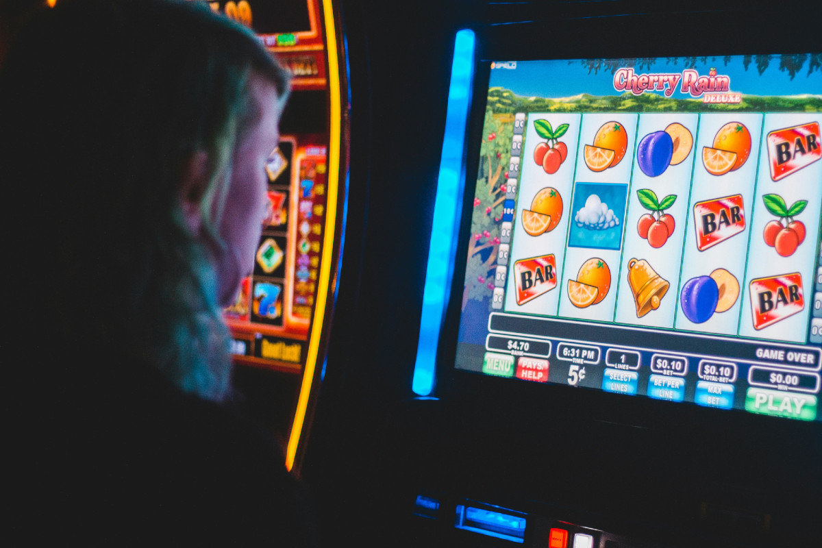 A side profile of a person illuminated by a slot machine.